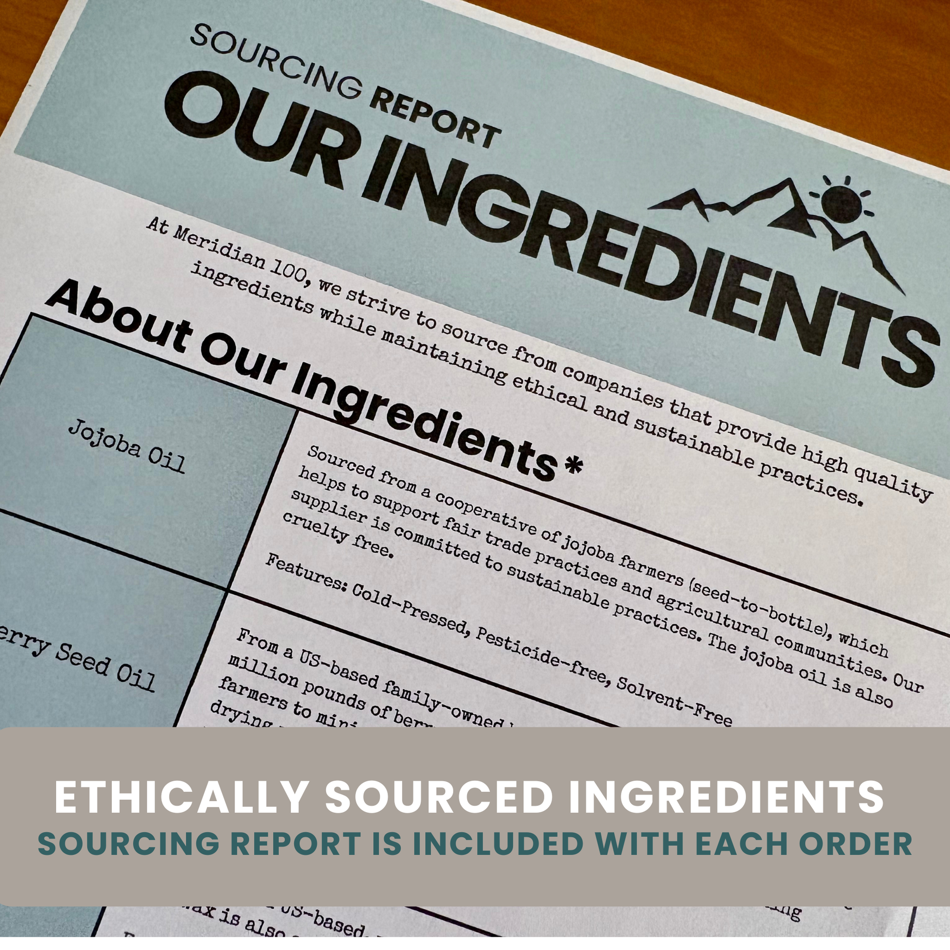 A close-up of a printed sourcing report and ingredients page for Meridian 100, showing text about Jojoba Oil and Raspberry Seed Oil on a white sheet over a wood surface, with a gray banner at the bottom reading 'ETHICALLY SOURCED INGREDIENTS' and 'SOURCING REPORT IS INCLUDED WITH EACH ORDER.'.