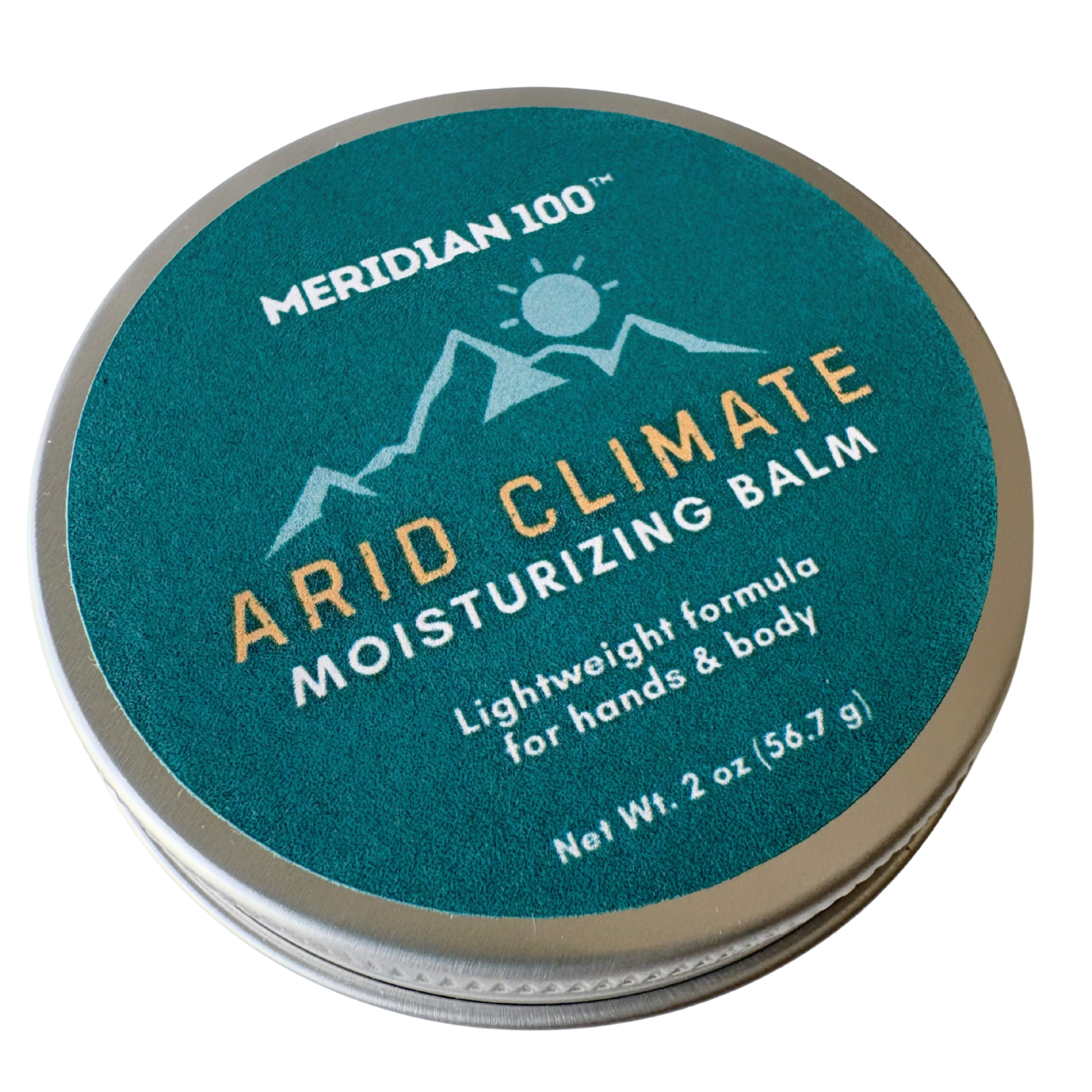 A round metal tin of Meridian 100 Arid Climate Moisturizing Balm, featuring a textured teal-green label with white and gold lettering on a white background.